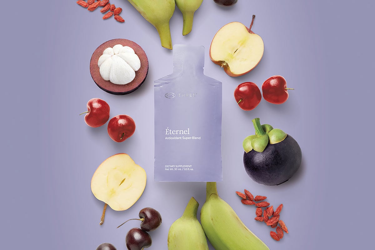 A pouch of Éternel by THREE surrounded by key ingredients, including antioxidants and CoQ10