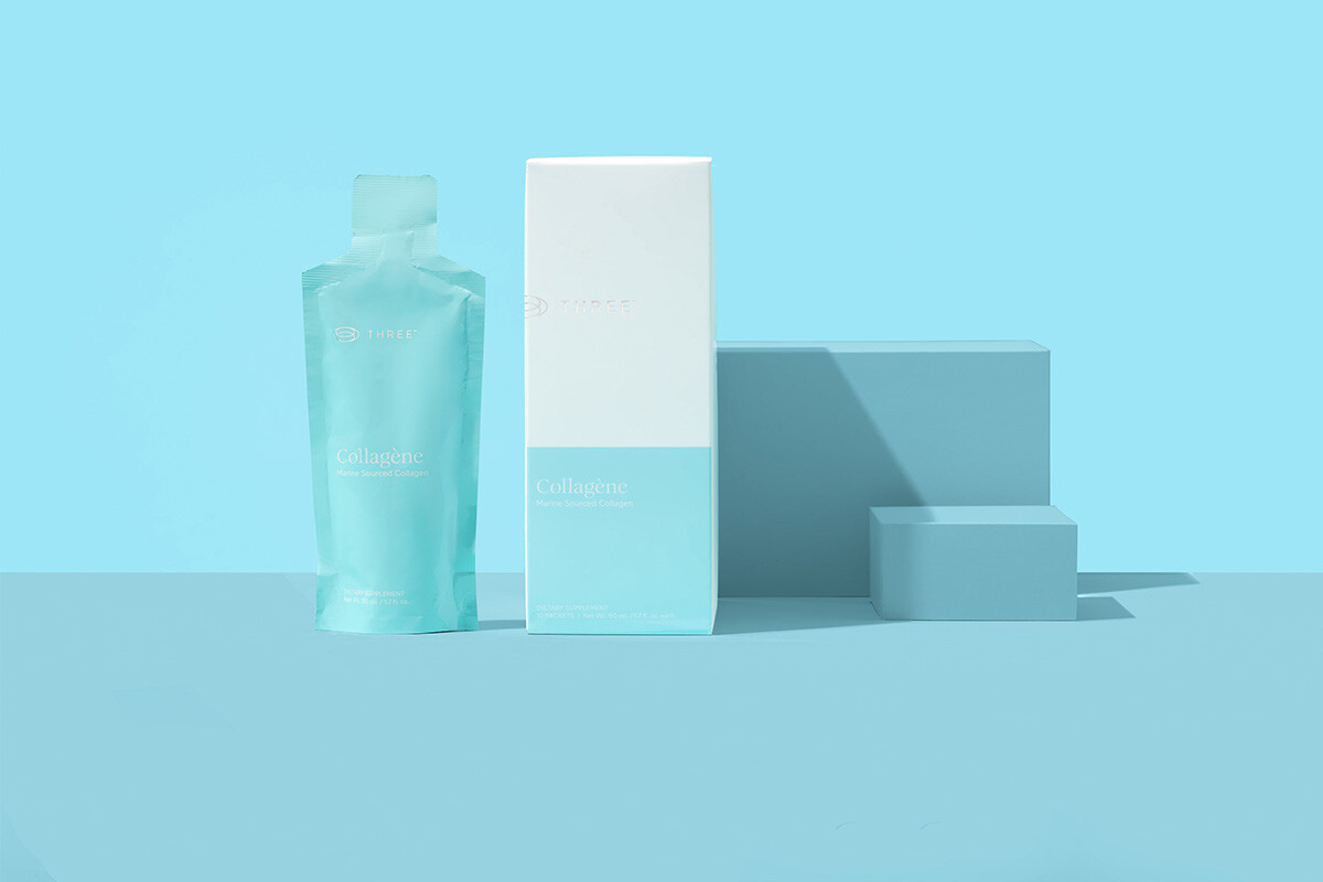 Collagène by THREE collagen supplement sitting against a vivid blue background