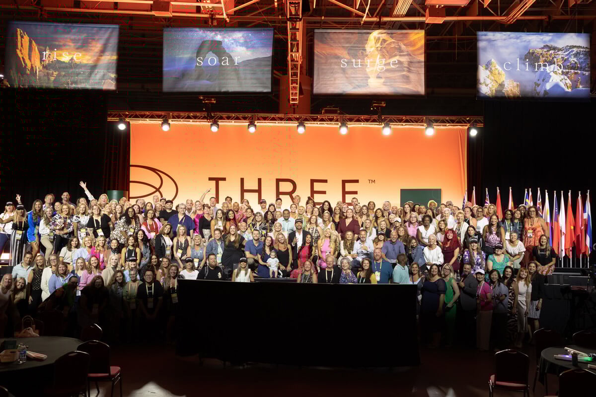 A group of brand ambassadors on stage at the 2024 THREE International Convention