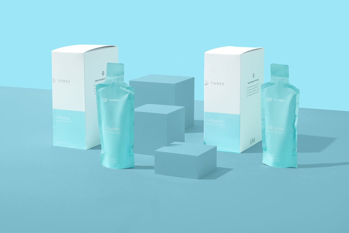 Collagène by THREE marine collagen supplement packets and boxes displayed on a geometric blue surface, highlighting convenient, on-the-go liquid collagen options.