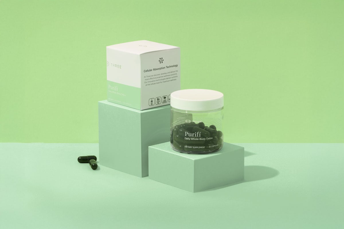 a container of Purifí by THREE International in a green setting