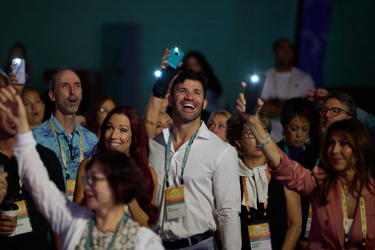 A group of attendees laughing and smiling at the 2024 THREE International Salt Lake Convention