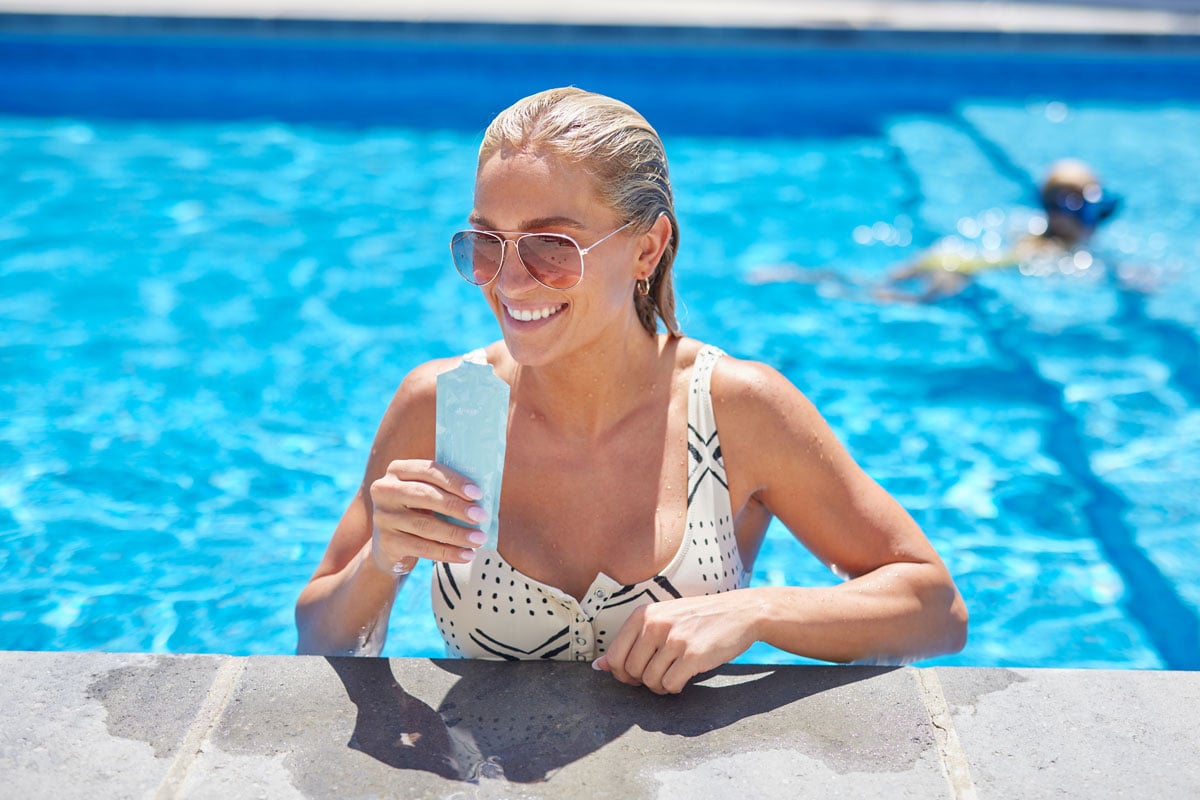 Blonde woman in a swimming pool enjoying a Collagene superior collagen supplementby THREE in the summer