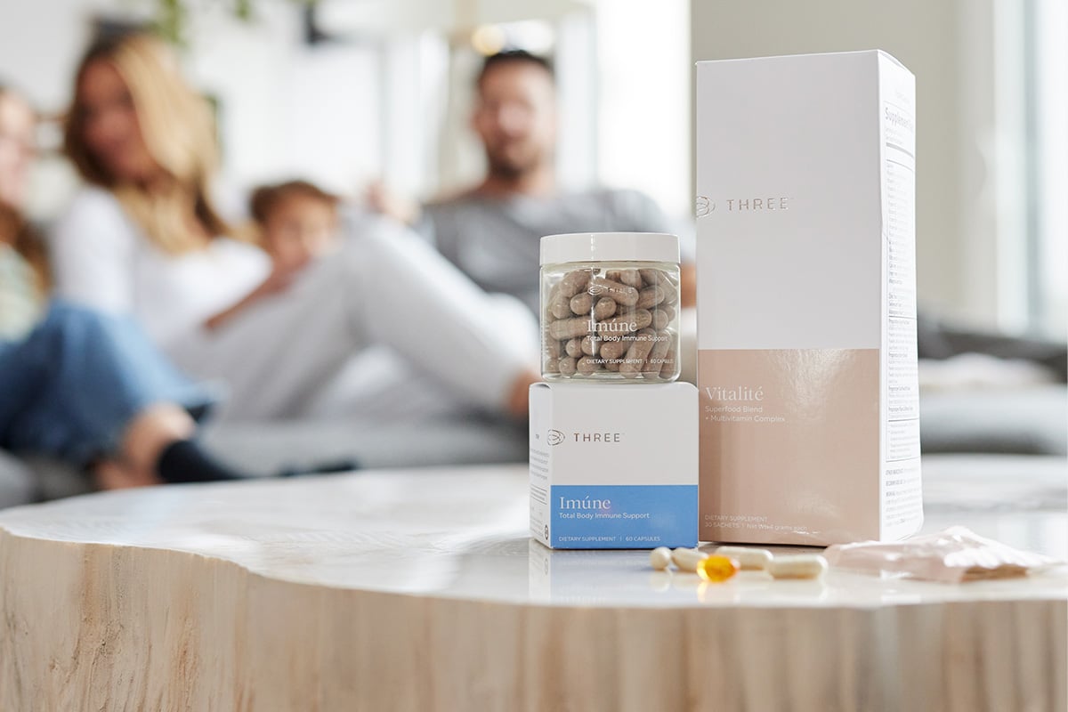 Three Supplements on a table with a family in the background