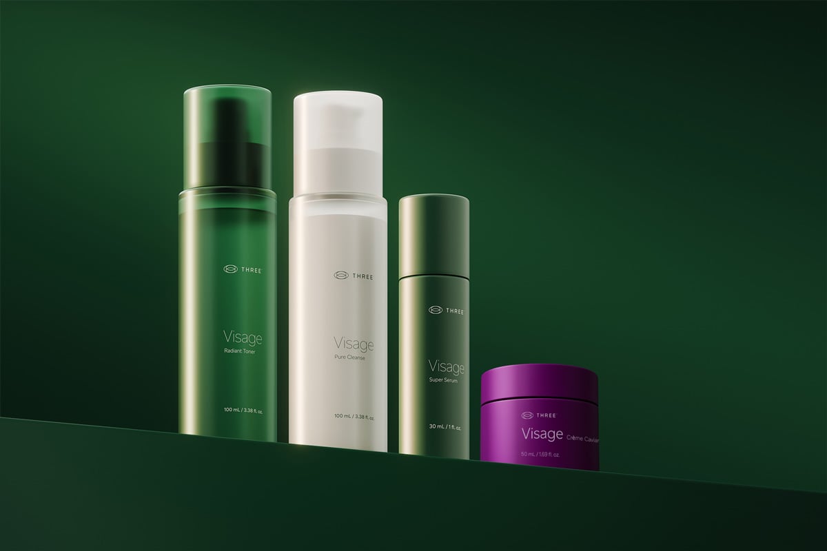 Visage Collection skincare products by THREE, including toner, cleanser, serum, and Crème Caviar moisturizer.