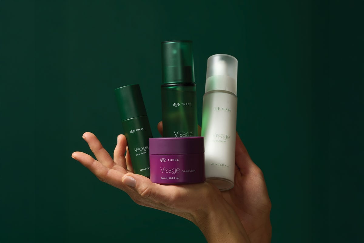 a woman holding the Visage Collection Skincare Routine by THREE International