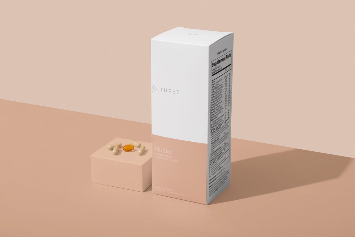 Vitalité by THREE daily multivitamin packet and packaging with capsules and omega softgel displayed.